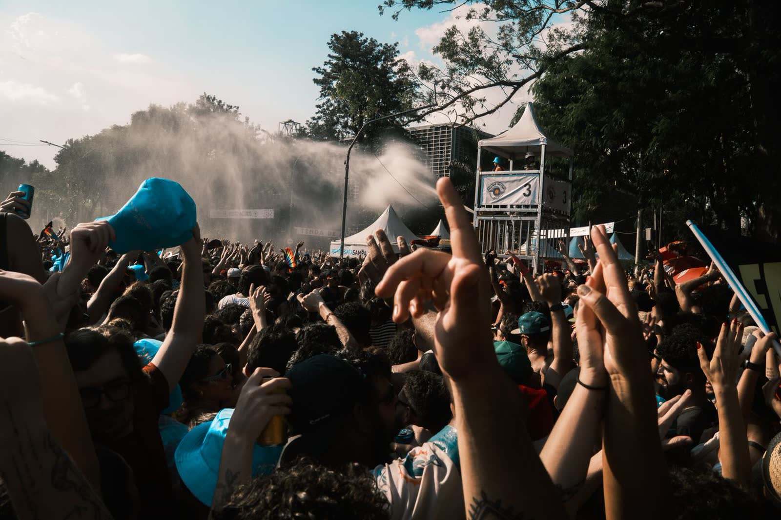 Crowd with hands raised at an outdoor music festival